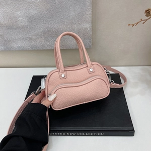Detail of pink lychee leather handbag featuring wave zipper pocket and silver hardware