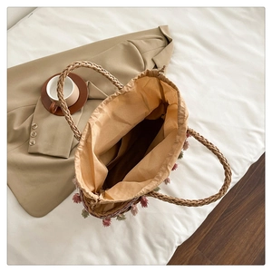 Detail of straw bag with colorful tassels, drawstring liner and spacious interior