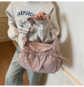 Close-up of pink canvas tote bag featuring cute bow accents and adjustable wide shoulder strap