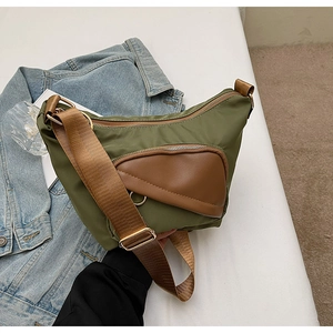 Detail of olive nylon crescent bag with brown leather pocket and adjustable strap