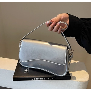 Détail du sac demi-lune argenté avec lettrage doré sur similicuir verni et poli