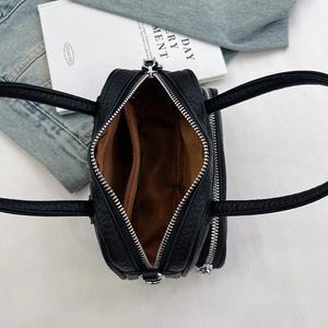 Top view of black pebbled leather tote showing brown lining and inner zipper pocket