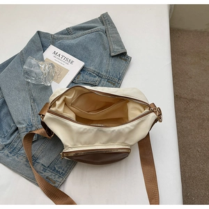 Detail shot of the spacious interior with zip pockets in a two-tone canvas shoulder bag