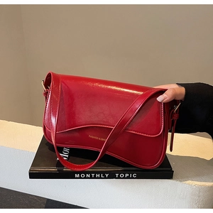 Gros plan du sac hobo rouge brillant en cuir effet huilé vintage avec détails dorés