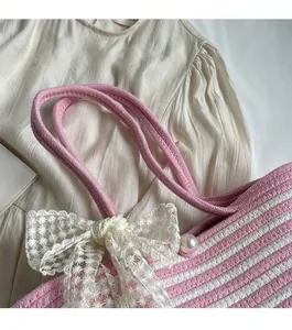 Close-up of pink and white striped woven bag featuring lace bow and pearl detail