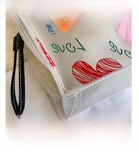 Detailed view of translucent frosted PVC tote bag featuring red heart and LOVE lettering