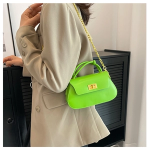 Detail of bright green mini chain bag with gold twist lock and knotted handle