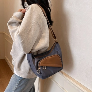 Women's casual navy canvas shoulder bag with brown leather pocket and gold ring zipper
