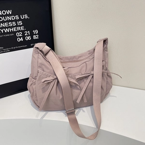 Minimalist dusty rose canvas shoulder bag featuring bow details and adjustable wide strap