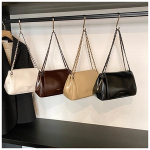 Close-up of vintage faux leather handbags with metal chain straps in four classic colors