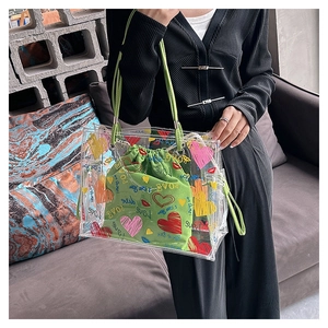 Detail of transparent PVC tote bag with green drawstring pouch and colorful love heart prints