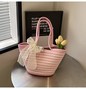 Detailed close-up of pink striped woven tote with lace bow and pearl decoration