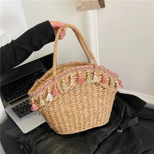 Handwoven straw tote bag with colorful tassels and a drawstring lining for beach vacation