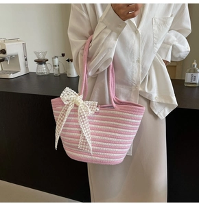 Detail of pink and white woven tote bag with large lace bow and pearl button accent