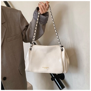 Detail of cream white leather shoulder bag featuring black and white chain strap