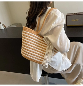 Detail of striped woven tote bag with white lace floral patches and rope handles