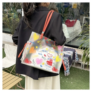 Detail of transparent tote bag featuring colorful graffiti hearts and orange shoulder straps