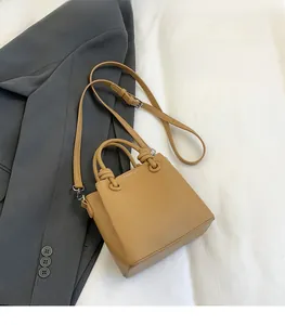 Detail of tan litchi leather texture on a chic handbag with adjustable strap