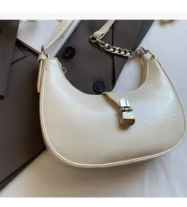 Detail of off-white crescent bag with silver piston buckle and textured leather finish