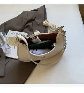 Spacious interior of beige moon-shaped shoulder bag showing large capacity for essentials