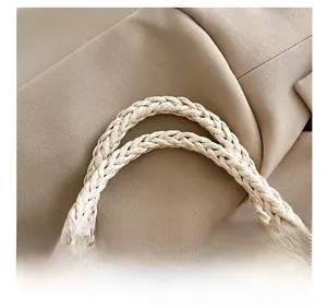 Detail showing the comfortable woven rope handle on a brown textured tote bag