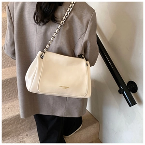 Detail of cream white leather crossbody bag with chain strap and metallic lettering