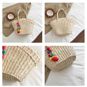Detail of woven straw tote bag featuring colorful pom-poms and drawstring lining