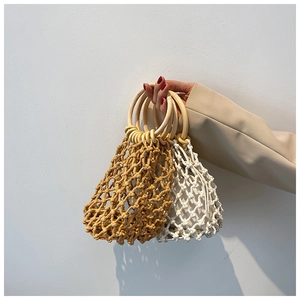 Detail of handmade woven mesh tote bag with round wooden handles in yellow and beige