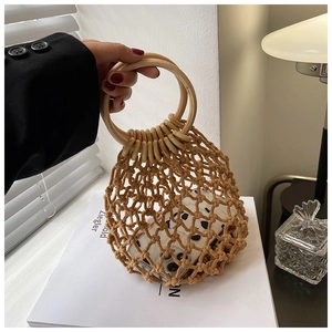 Detail of hollow hand-woven straw bag with round wooden handle and mesh texture