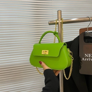 Neon green mini chain bag with gold metal clasp and knotted top handle design