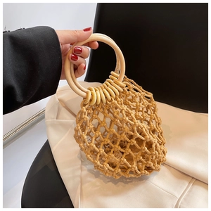 Detail of bohemian handmade woven straw bag featuring circular wooden handles and mesh pattern
