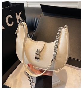 Détail du sac hobo crème avec bandoulière chaîne argentée et fermoir métal