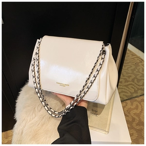 Detail of white glossy patent leather shoulder bag with chic silver chain strap