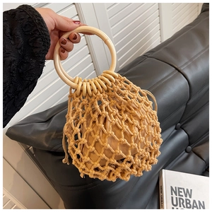 Detail of handmade woven straw bag with circular wooden handles and canvas drawstring