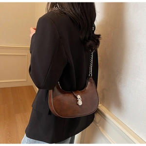 Détail du sac à bandoulière demi-lune marron foncé avec chaîne argentée et boucle