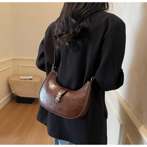 Détail du sac demi-lune marron foncé avec texture brillante et boucle argentée