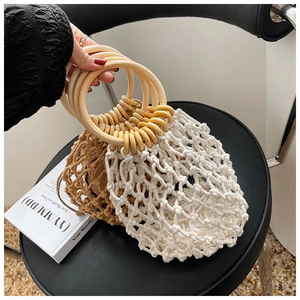 Detail of dual-tone hollow handmade woven bag with large wooden circular ring handles