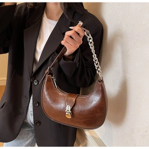 Detail of dark brown hobo bag with glossy oil wax leather and silver chain strap