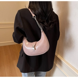 Vue détaillée d'un sac demi-lune rose avec chaîne argentée et boucle métallique sur un modèle