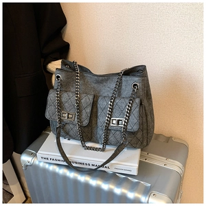 Detail of grey fabric shoulder bag with silver chain strap and diamond quilted pockets