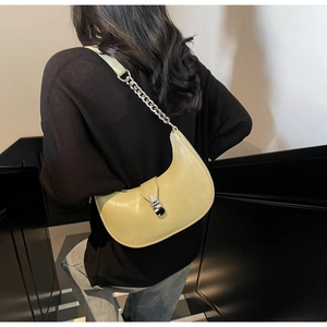 Détail du sac croissant vert pâle avec bandoulière en chaîne argentée et cuir