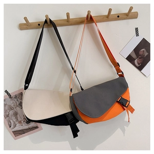 Detail view of stylish contrast color messenger bags with plastic buckles on a wooden hook
