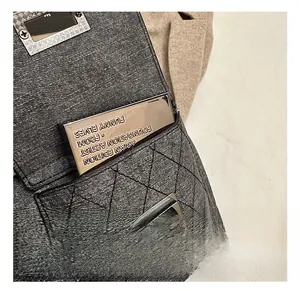 Macro shot of silver swivel lock and quilted texture on a grey vintage motorcycle bag