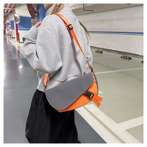 Detail of grey and orange messenger bag with adjustable strap and plastic buckle