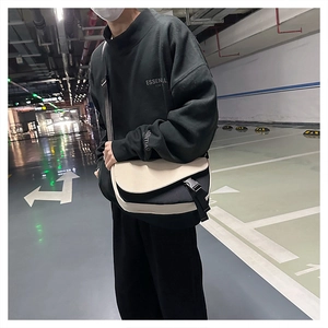 Detail of contrast messenger bag with plastic buckle and nylon strap in street style