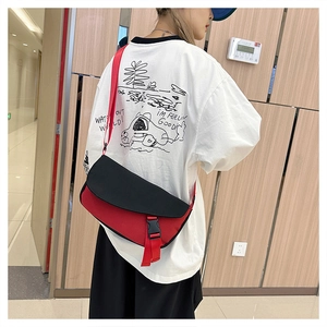 Detail of red and black crossbody messenger bag with canvas texture and buckle closure
