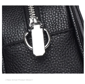 Close-up of litchi texture leather and silver metal zipper on black bowling bag