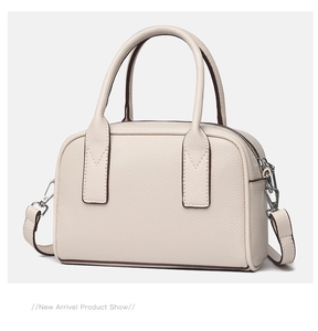 Detail of cream lychee leather texture and contrast edge stitching on the crossbody bag