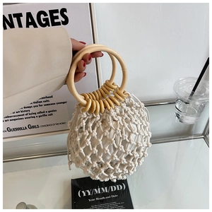 Handmade woven straw tote bag with round wooden handles and drawstring inner liner
