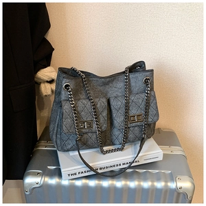 Detail of dark grey denim tote with quilted pockets and vintage silver chain straps